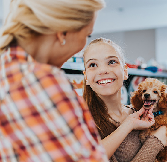 Mutter und Kind mit Hund auf dem Arm